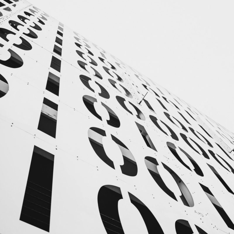Low angle view of a steel facade featuring abstract numbers and patterns, creating a modern architectural design.
